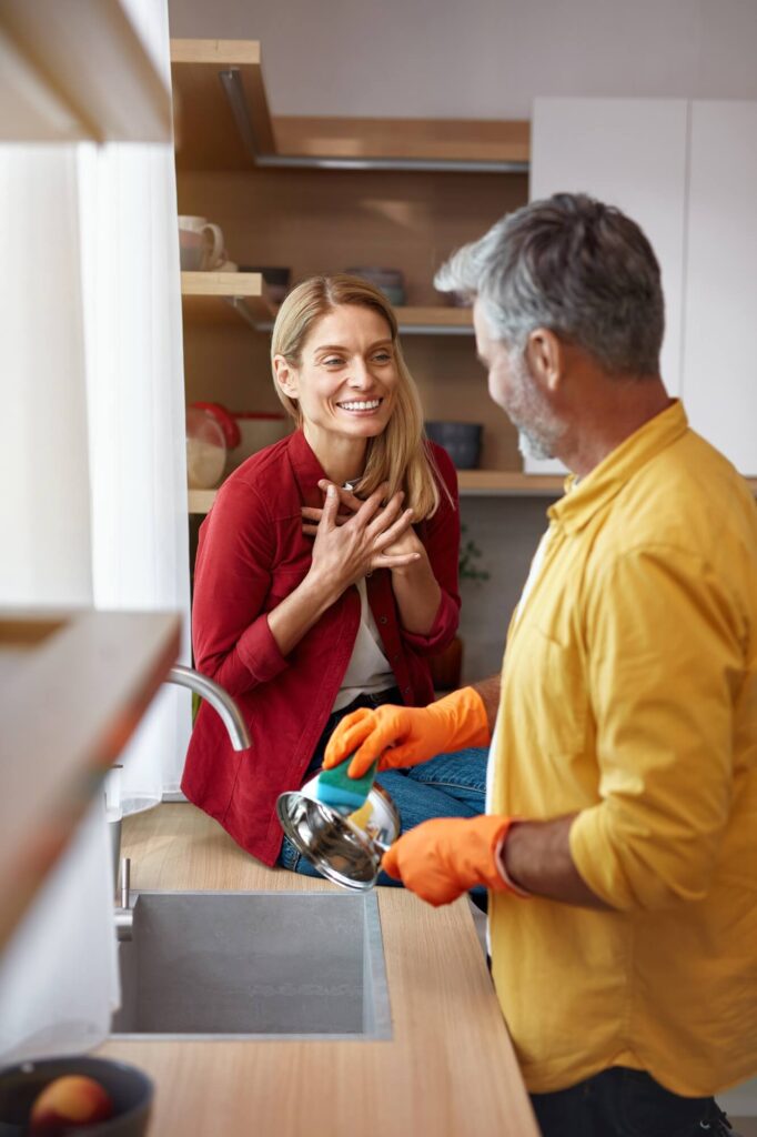 senior couple cleaning dishes at kitchen vertical shot of man washing dishes